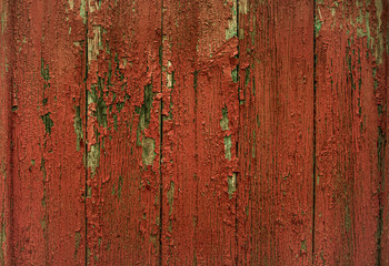Painted in red color wooden planks with cracks.