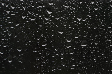 Raindrops on glass dark background