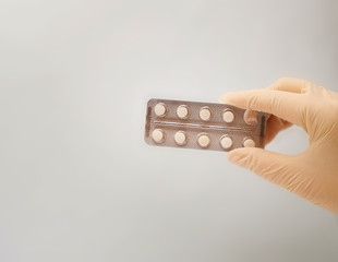female hand holds a pack of pills