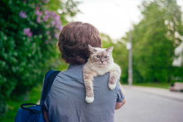 A man with a cat for a walk in the park