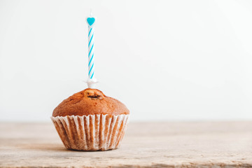 Chocolate cupcake with candle on wooden table. Copy, empty space for text