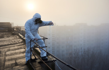 Researcher wearing protective outfit is conducting the study, using blue reagent in glass flask on...