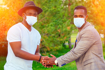 african brazilian friend outdoors hand shaking park usian antibacterial sanitizer gel