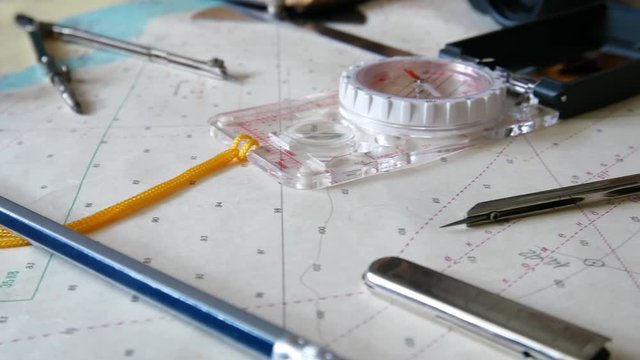 Close up of navigation tools on the sea map. Compass, navigation dividers, and other. Almost all that need for sea navigation and preparing for travel at home. The same tools are used in architecture.