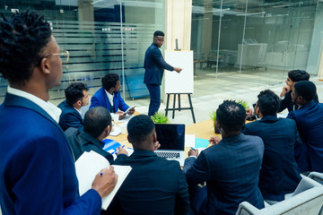 Group of business international people looking at the graph on flipchart in modern eco office