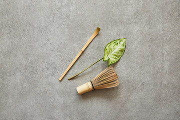 Fototapeta na wymiar Matcha tea accessories and a leaf on a gray background.