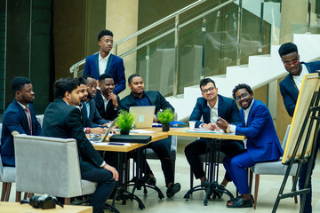 Group of business international people looking at the graph on flipchart in modern eco office