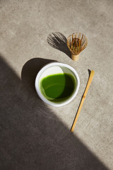 Tea matcha composition with shadow on a gray background.