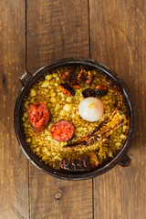 Spanish gastronomy: Typical spanish cuisine: an earthenware bowl with migas, onion, chorizo and dried peppers