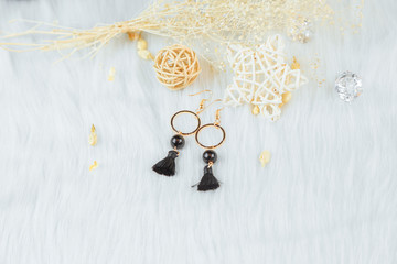 Obraz na płótnie Canvas Gold hooped earrings;Black tassels and rattan ornaments.These earrings are handmade by us.Black fringed decoration.Nobility and grace.The earrings are made of metal and the color is like gold.
