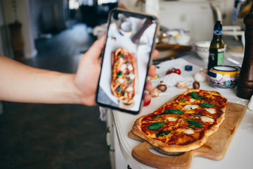 Selective focus on fresh homemade delicious pizza on kitchen counter. Food blogger make photo or...