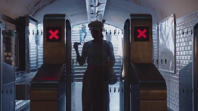 A young girl passes through the turnstile in the subway in Paris