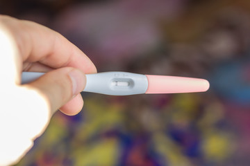 Negative pregnancy test over the color background.