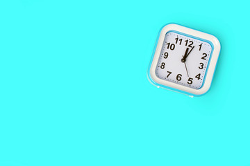Blue alarm clock on a blue background. Shot from above. Space for text.