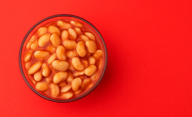 Baked beans in tomato sauce isolated on red background