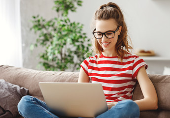 Joyful relaxed woman using laptop with interest at home.