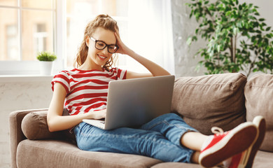 Joyful relaxed woman using laptop with interest at home. - obrazy, fototapety, plakaty