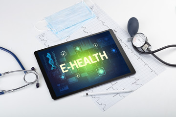 Tablet pc and medical stuff with E-HEALTH inscription, prevention concept