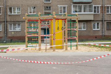 Fototapeta na wymiar An empty carousel and a playground tied with prohibitive ribbons in Russia due to the global impact of COVID-19