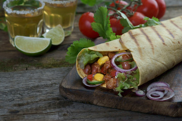 burrito with tequila wooden background