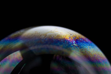 Macrophotography of a soap bubble. Multicolored streaks on the surface of the soap bubble