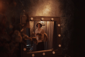 Sexy woman in a red skirt posing outdoors in the park.A bitchy girl smokes a cigarette and catches her eye.Beautiful model in various poses. Summer nature,all in green and red colors.Glasses on a girl