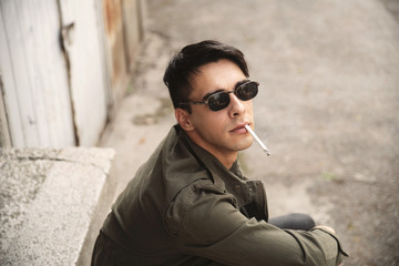 Young man smoking cigarette outdoor