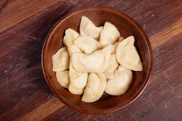 vareniki with cheese are Ukrainian foods on a wood background