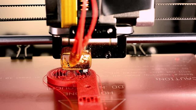 3d printer manufacturing a red part in abs