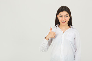 beautiful young woman in a white shirt on a white background with hand gesture	
