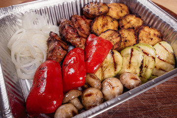 Grilled potatoes with grilled vegetables and meat on a baking tray