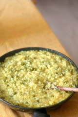 Pan with rice, peas and turmeric on a table. Selective focus.