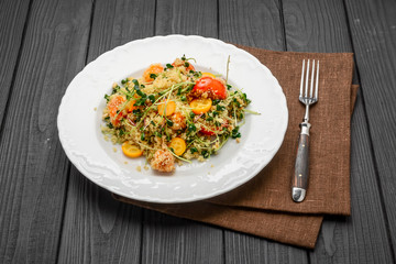 salad with bulgur and vegetables, Tabbouleh, on a dark wood background. tinting.