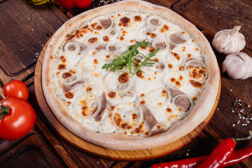 Pizza with sliced vegetables on rustic wood, vintage style