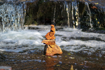 Fototapeta na wymiar Stack of stones in waterfall