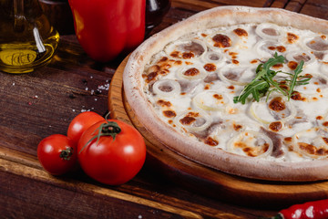 Pizza with sliced vegetables on rustic wood, vintage style