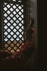 Sexy woman in a red skirt posing outdoors in the park.A bitchy girl smokes a cigarette and catches her eye.Beautiful model in various poses. Summer nature,all in green and red colors.Glasses on a girl