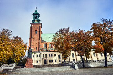 Fototapeta na wymiar Statue and Gothic cathedral church in autumn in Gniezno .