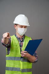 Young engineer worker wear a white helmet and medical mask