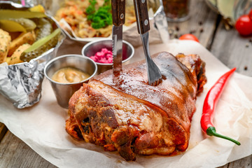 fried pork leg with potatoes on a wooden board