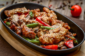 fried meat with vegetables in a pan