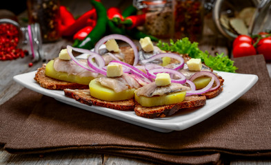 Open sandwich with herring, onion, potato and butter