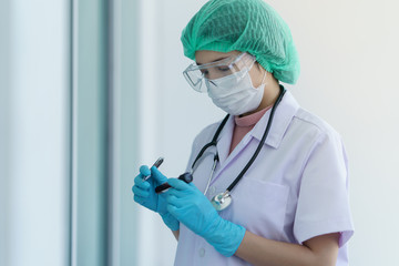 Fototapeta premium Doctor's hand holding a test tube with contaminated blood sample inside, other hand writing.