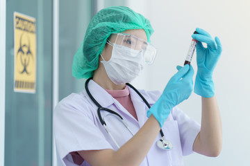 Doctor's hand holding a test tube with contaminated blood sample inside.