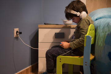 isolated boy with phone and headphones in his bedroom