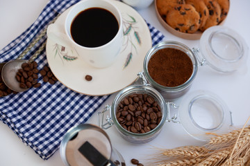 White cup of coffee top view. Ground coffee and grain. Breakfast is on the table. Coffee background. An invigorating drink still life. Food at home.