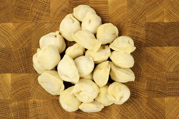 homemade raw pastry dumplings with meat filling on a wooden Board, pelmeni
