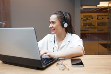 Online interview, business or personal conversation online, concept. Young attractive woman in headphones