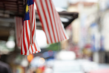 (Focus on the flags) View of some Malaysian national flags in the foreground and a blurred road in...