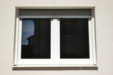 Moderne Fenster in einer gemauerten, verputzten und gestrichenen Fassade eines modernen Wohnhauses
